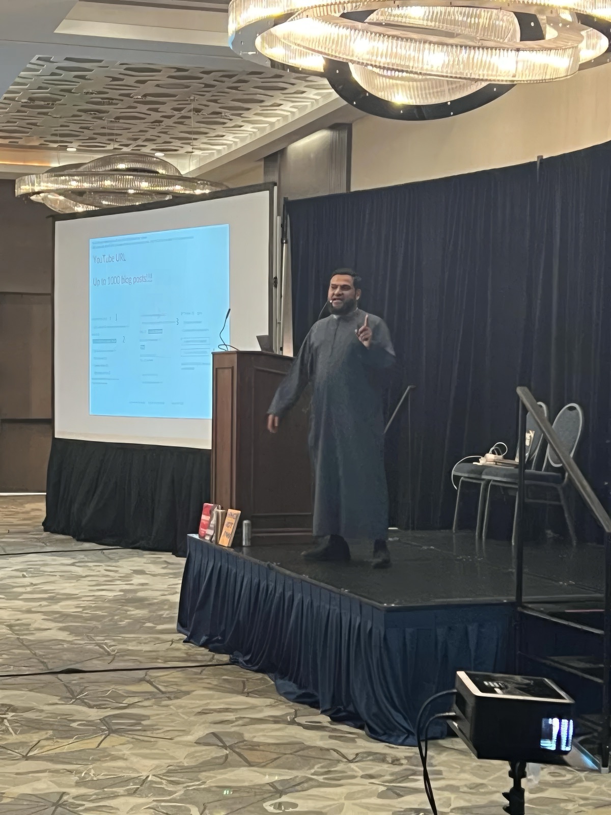 Muhammad Asmal presenting on stage at an event in Miami